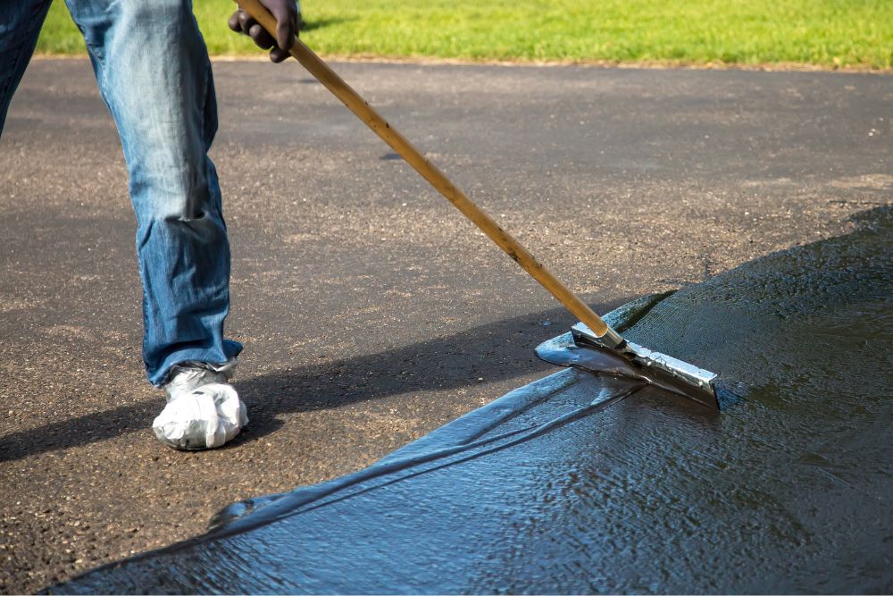 Man sealing an exposed aggregate concrete driveway