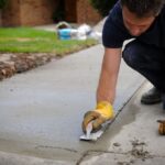 Man repaving a concrete driveway