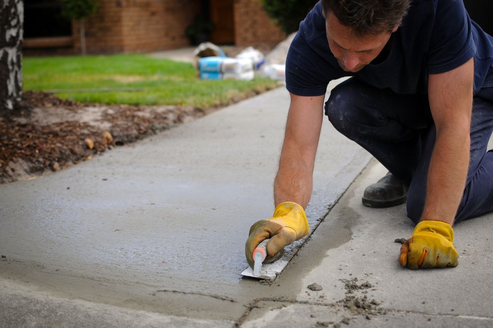 Man repaving a concrete driveway