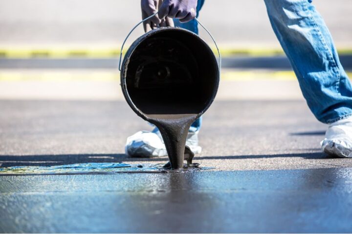 Man sealing an exposed aggregate concrete driveway